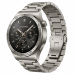 Huawei GT5 Pro 46mm – Titanio. Este reloj inteligente de alta gama se presenta en una vista de tres cuartos, mostrando su caja de 46 mm y su correa de eslabones , ambas fabricadas en titanio de color gris metálico. La pantalla circular está encendida y muestra una esfera analógica detallada con subesferas para pasos, fecha y ritmo cardíaco, junto con el logotipo de la marca. En el lateral derecho se aprecian la corona giratoria texturizada y un botón físico plano. El bisel tiene marcas numéricas grabadas. El dispositivo está centrado sobre un fondo blanco puro con iluminación de estudio suave.